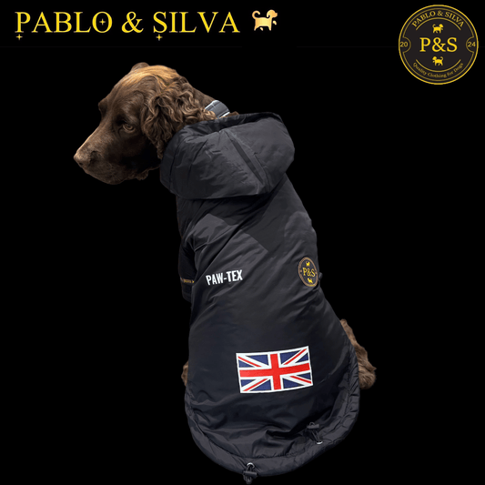 Dog wearing the Pablo & Silva waterproof winter jacket with a British flag patch, branded 'Pablo & Silva' on a black background.